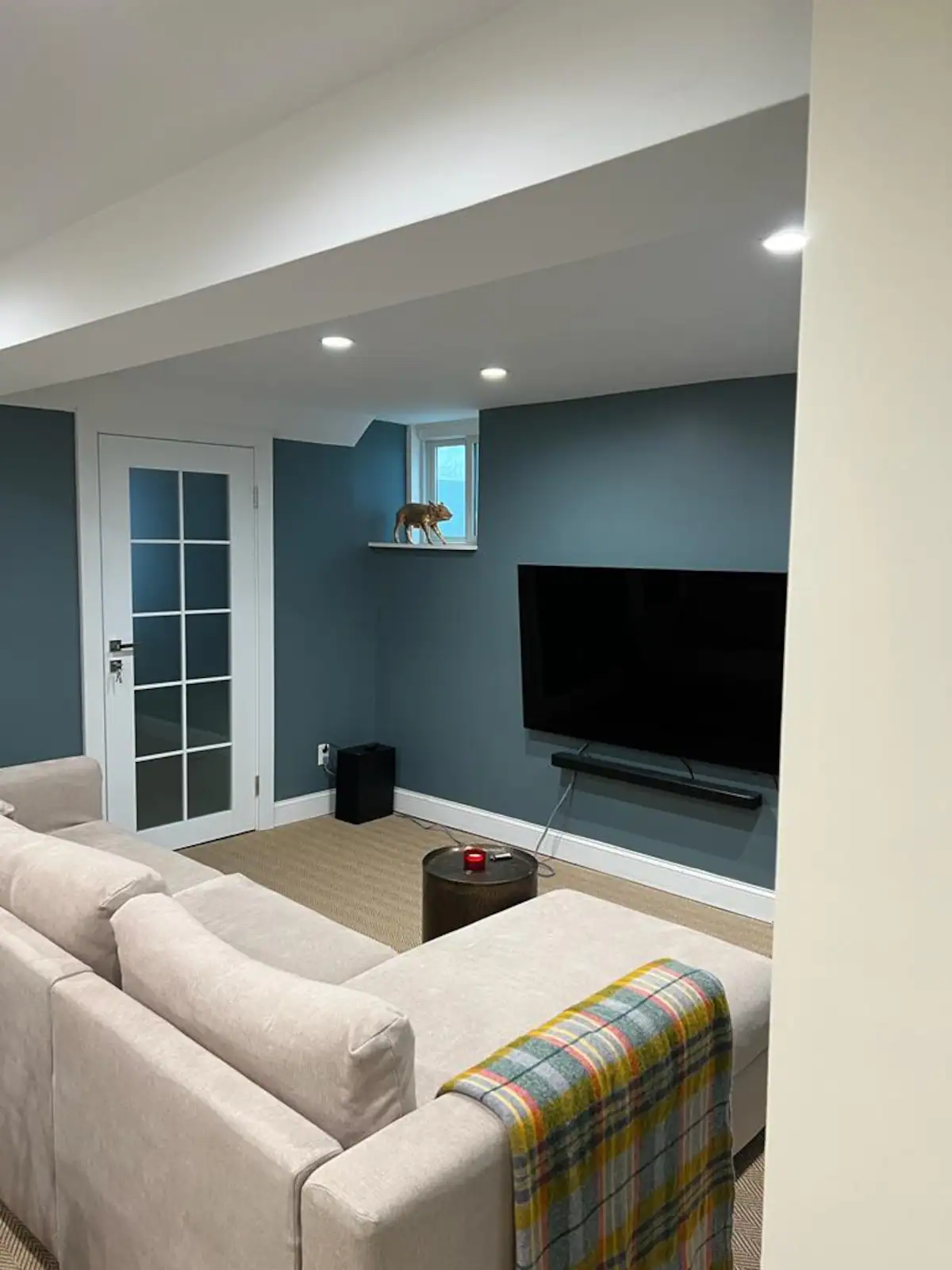 Living room with teal accent wall and large TV